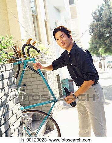 Portrait of a young man carrying a bicycle into a house View Large Photo Image Stock Image - Portrait of a young man carrying a bicycle into a house. Fotosearch