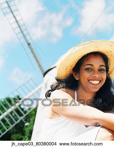 Portrait of a young woman wearing a straw hat looking at camera smiling View Large Photo Image Picture - Portrait of a young woman wearing a straw hat looking at camera smiling. Fotosearch