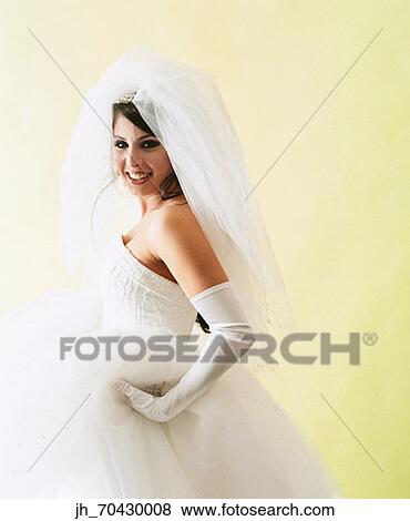 Portrait of a young woman wearing a bridal gown smiling View Large Photo Image Stock Photo - Portrait of a young woman wearing a bridal gown smiling. Fotosearch