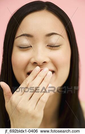 Portrait of a young woman with he r hand on her mouth View Large Photo Image Stock Photograph - Portrait of a young woman with he r hand on her mouth. Fotosearch