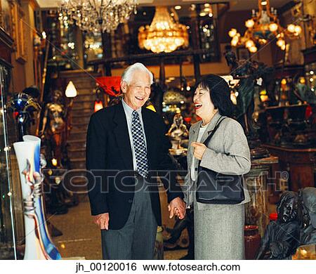 Portrait of an senior couple standing together holding hands laughing View Large Photo Image Stock Photograph - Portrait of an senior couple standing together holding hands laughing. Fotosearch