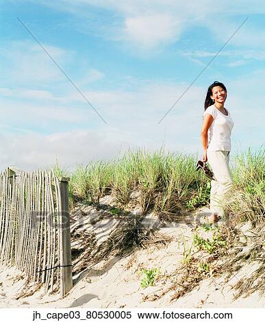 Portrait of young woman standing on the beach View Large Photo Image Stock Photography - Portrait of young woman standing on the beach. Fotosearch