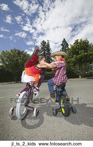 Stock Photograph - Rear view of a young boy and girl sitting on bicycles and fighting. Fotosearch