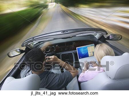Rear view of a young couple driving in a convertible car View Large Photo Image Stock Image - Rear view of a young couple driving in a convertible car. Fotosearch