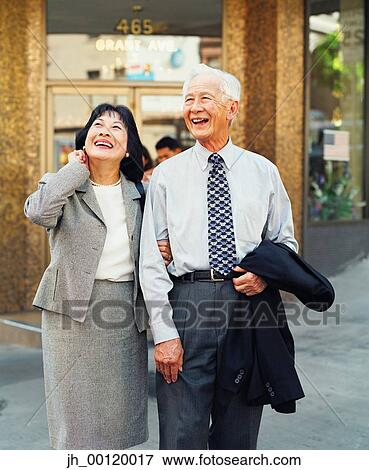 Senior couple walking together looking up View Large Photo Image Stock Photo - Senior couple walking together looking up. Fotosearch