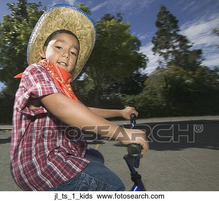 Side profile of a young boy in a straw hat riding a bicycle View Large Photo Image Stock Photograph - Side profile of a young boy in a straw hat riding a bicycle. Fotosearch