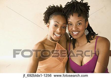 Two young women smiling looking at camera View Large Photo Image Stock Photograph - Two young women smiling looking at camera. Fotosearch
