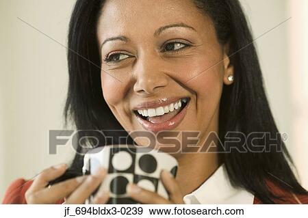 Woman holding a cup smiling View Large Photo Image Stock Photo - Woman holding a cup smiling. Fotosearch