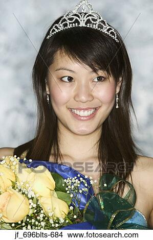 Picture - Young beauty pageant winner holding a bouquet of flowers smiling. Fotosearch