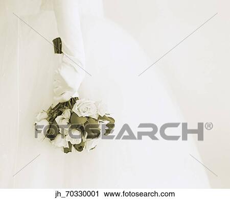 Young bride holding a bouquet of flowers View Large Photo Image Stock Image - Young bride holding a bouquet of flowers. Fotosearch