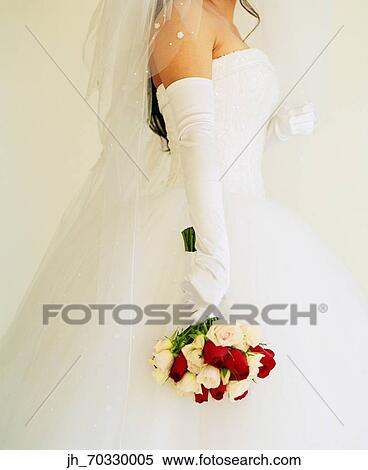 Young bride holding a bouquet of flowers View Large Photo Image Stock Photography - Young bride holding a bouquet of flowers. Fotosearch