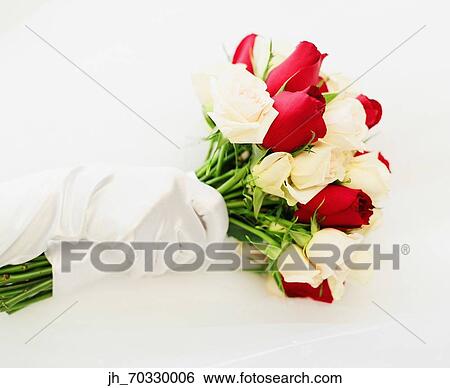 Stock Photograph - Young bride holding a bouquet of roses. Fotosearch