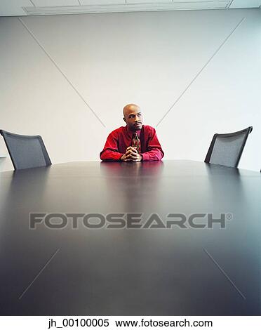 Young businessman sitting at a table View Large Photo Image Stock Photography - Young businessman sitting at a table. Fotosearch