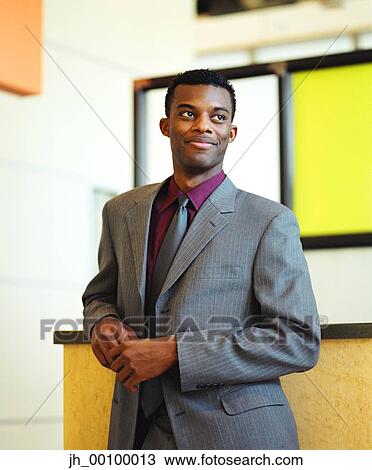 Young businessman standing looking away View Large Photo Image Stock Image - Young businessman standing looking away. Fotosearch