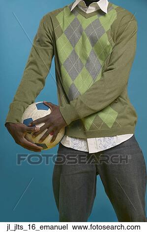 Young man holding a football against his hip View Large Photo Image Stock Image - Young man holding a football against his hip. Fotosearch