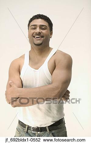 Young man standing with his arms folded looking at camera View Large Photo Image Stock Image - Young man standing with his arms folded looking at camera. Fotosearch