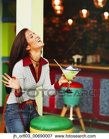 Young woman holding a cocktail glass View Large Photo Image Stock Photo - Young woman holding a cocktail glass. Fotosearch