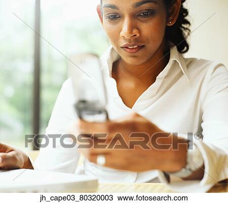 Young woman holding a mobile phone View Large Photo Image Stock Image - Young woman holding a mobile phone. Fotosearch