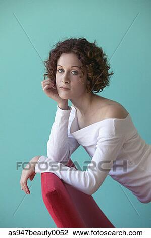Young woman leaning on a chair View Large Photo Image Stock Image - Young woman leaning on a chair. Fotosearch
