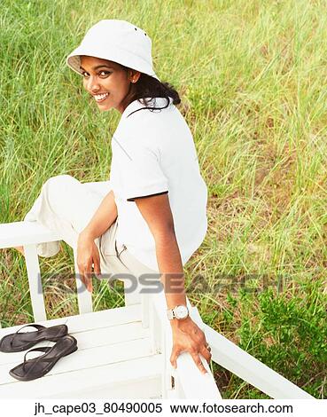 Stock Photography - Young woman sitting on a railing. Fotosearch