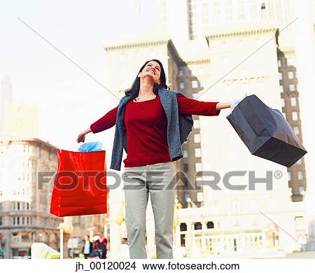 Young woman smiling holding shopping bags View Large Photo Image Picture - Young woman smiling holding shopping bags. Fotosearch