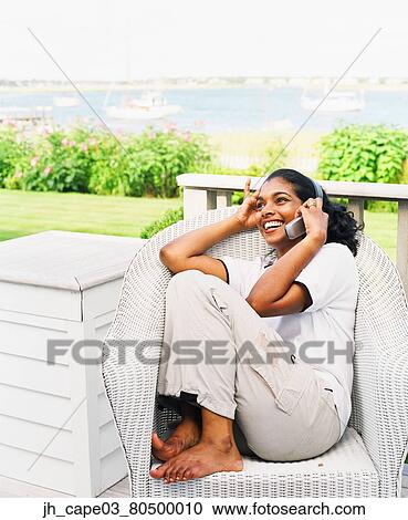 Stock Image - Young woman talking on a mobile phone. Fotosearch