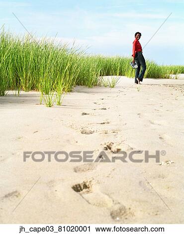 Young woman walking on sand View Large Photo Image Stock Image - Young woman walking on sand. Fotosearch
