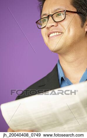 Businessman smiling holding a newspaper View Large Photo Image Stock Photo - Businessman smiling holding a newspaper. Fotosearch