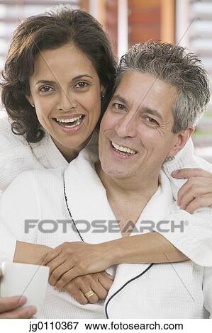 Couple holding each other looking at camera View Large Photo Image Stock Photo - Couple holding each other looking at camera. Fotosearch