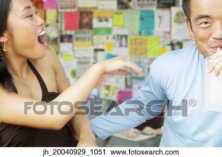 Couple sitting together laughing View Large Photo Image Stock Image - Couple sitting together laughing. Fotosearch