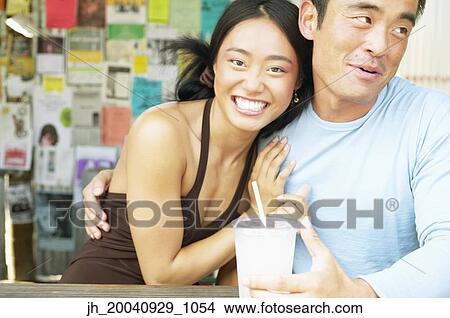 Picture - Couple sitting together smiling. Fotosearch