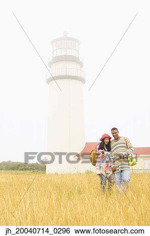 Couple walking through a field View Large Photo Image Stock Photograph - Couple walking through a field. Fotosearch