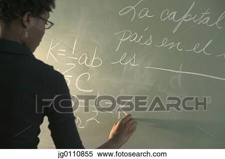 Female teacher writing on a chalkboard View Large Photo Image Stock Photography - Female teacher writing on a chalkboard. Fotosearch