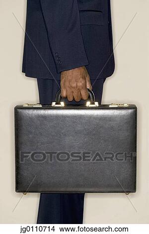 Hand of a businessman holding a briefcase View Large Photo Image Picture - Hand of a businessman holding a briefcase. Fotosearch