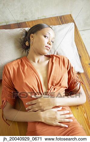 High angle view of a young woman lying down View Large Photo Image Stock Image - High angle view of a young woman lying down. Fotosearch