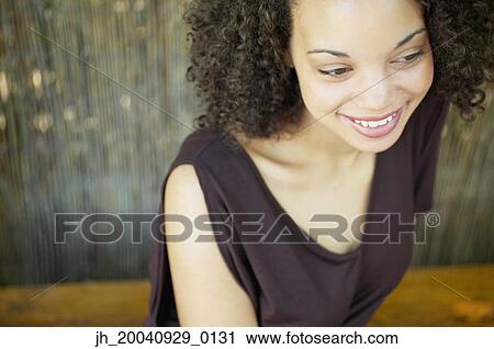 High angle view of a young woman smiling View Large Photo Image Stock Image - High angle view of a young woman smiling. Fotosearch