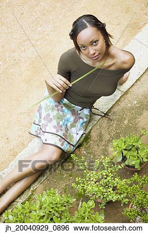 Stock Photograph - High angle view of a young woman sitting looking up. Fotosearch