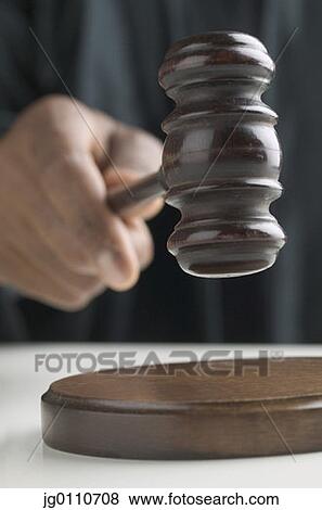 Stock Photo - Human hand holding a gavel. Fotosearch
