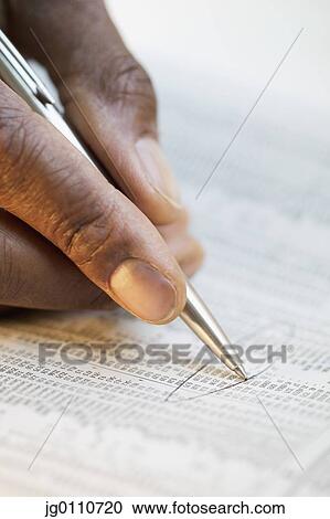 Human hand holding a pen encircling numbers on a newspaper View Large Photo Image Stock Image - Human hand holding a pen encircling numbers on a newspaper. Fotosearch
