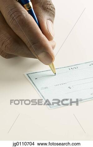 Picture - Human hand holding a pen signing a cheque. Fotosearch