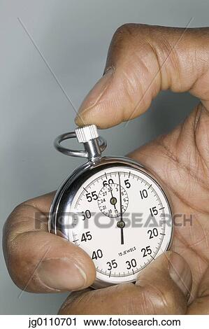 Stock Image - Human hand holding a stopwatch. Fotosearch