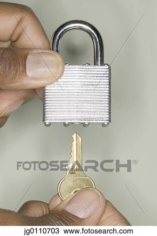 Human hands inserting a key into a padlock View Large Photo Image Stock Image - Human hands inserting a key into a padlock. Fotosearch