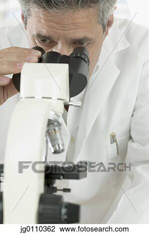Male scientist looking through a microscope View Large Photo Image Stock Image - Male scientist looking through a microscope. Fotosearch