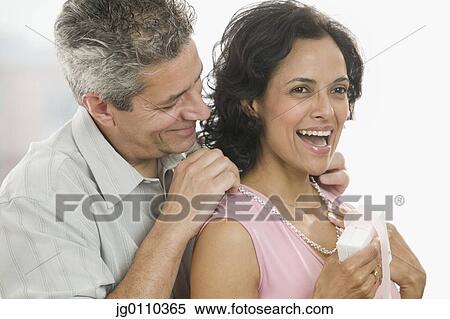 Man helping a woman put on a necklace View Large Photo Image Stock Photography - Man helping a woman put on a necklace. Fotosearch