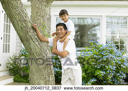 Mature man standing with a young boy sitting on his shoulders View Large Photo Image Stock Photo - Mature man standing with a young boy sitting on his shoulders. Fotosearch