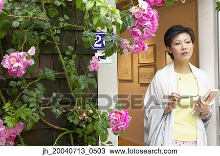 Mid adult woman standing holding eye glasses View Large Photo Image Stock Image - Mid adult woman standing holding eye glasses. Fotosearch