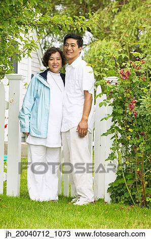 Portrait of a couple standing together on a lawn View Large Photo Image Stock Image - Portrait of a couple standing together on a lawn. Fotosearch