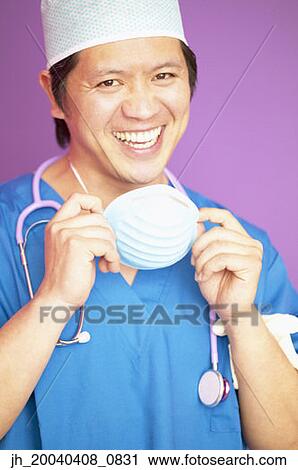 Portrait of a male doctor wearing full scrubs smiling View Large Photo Image Stock Image - Portrait of a male doctor wearing full scrubs smiling. Fotosearch