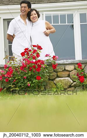 Stock Image - Portrait of a mid adult couple holding each other. Fotosearch