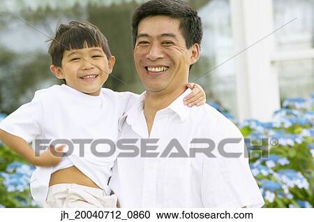 Stock Image - Portrait of a mid adult man holding a young boy. Fotosearch